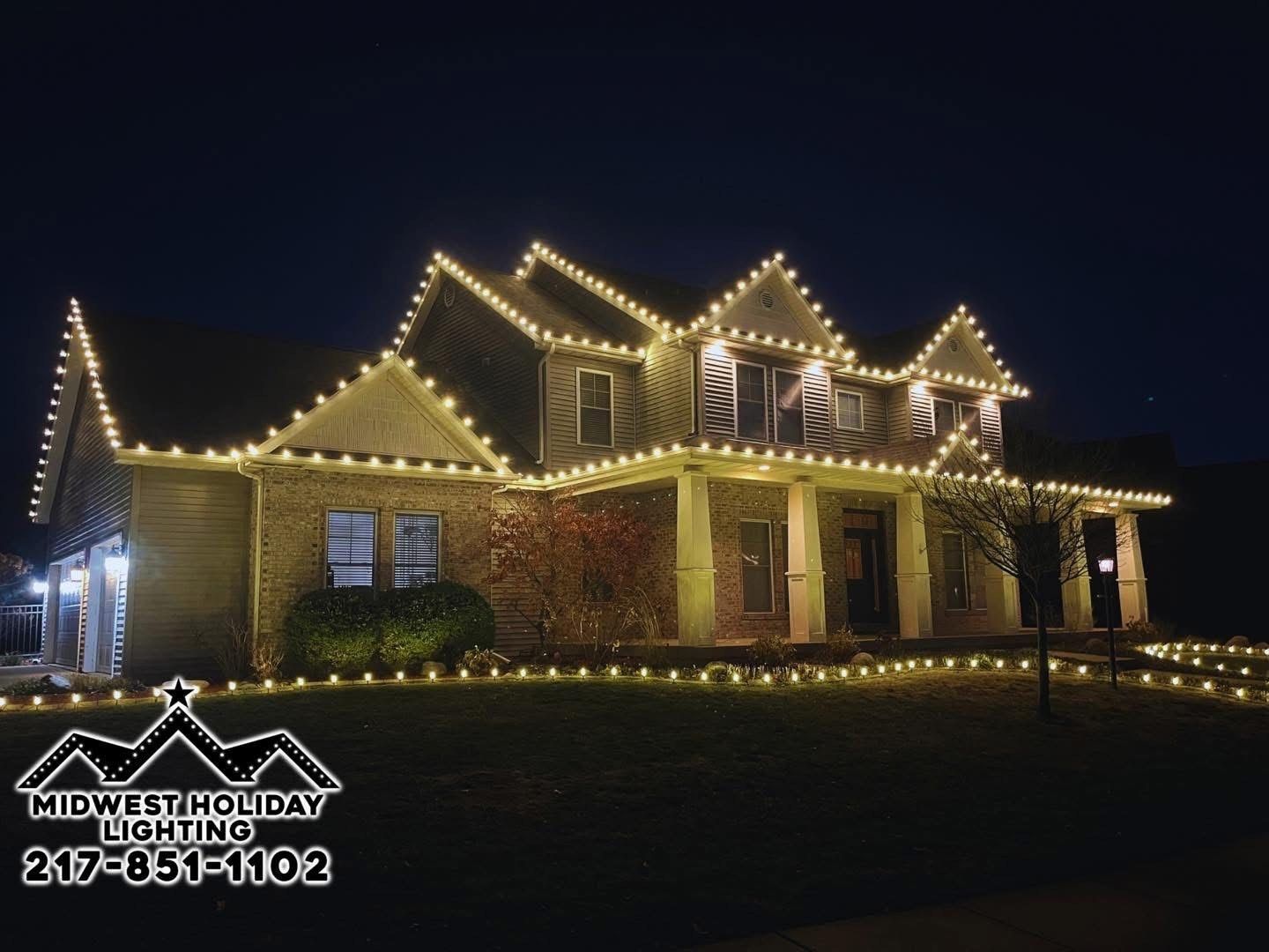 Warm white C9 Christmas lights outlining every roofline of a two-story Central Illinois home