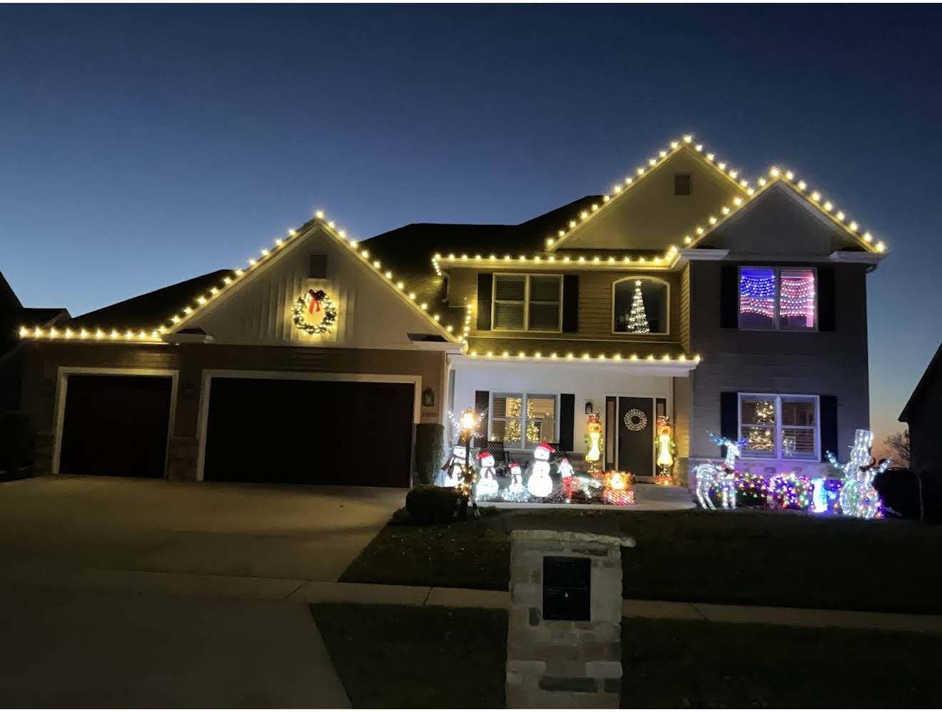 Professionally installed warm white Christmas lights on a home like those we light in Tolono, Illinois